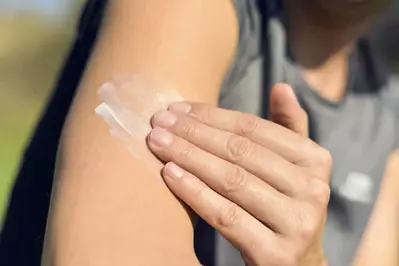 person putting on sunscreen